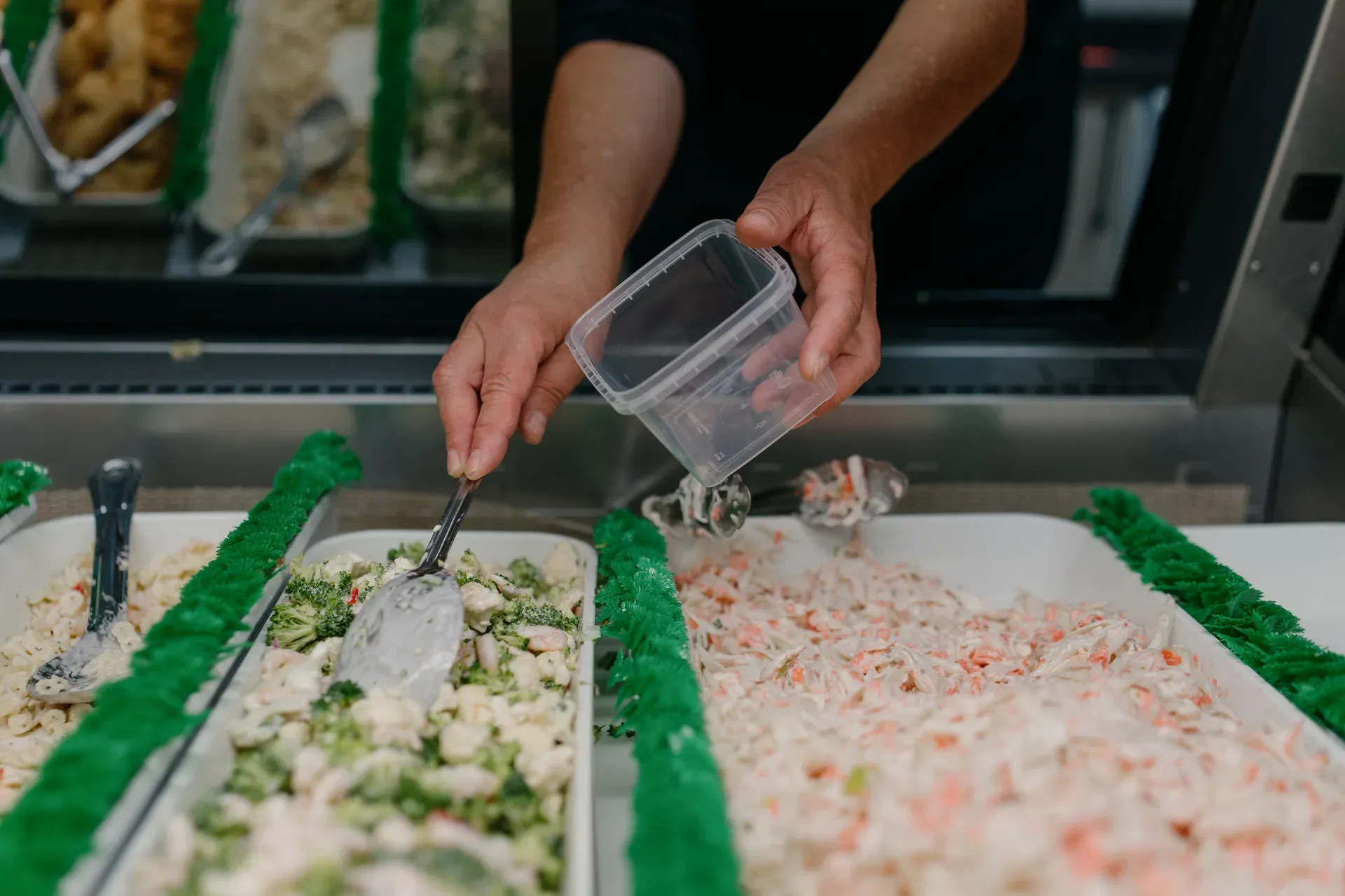 Employée qui sert des salades au comptoir traiteur, Pêcherie Manicouagan Les Escoumins