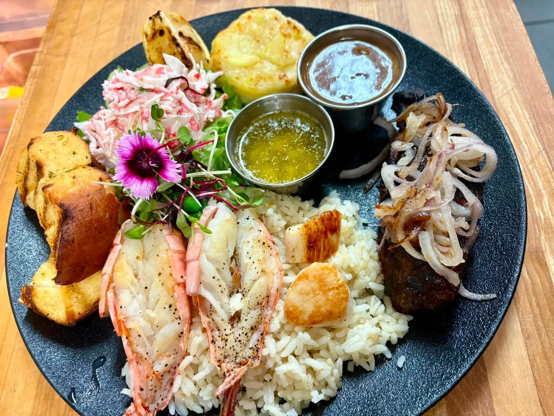Terre et mer : bavette de bœuf Angus aux oignons, crevettes papillons et pétoncles sur riz